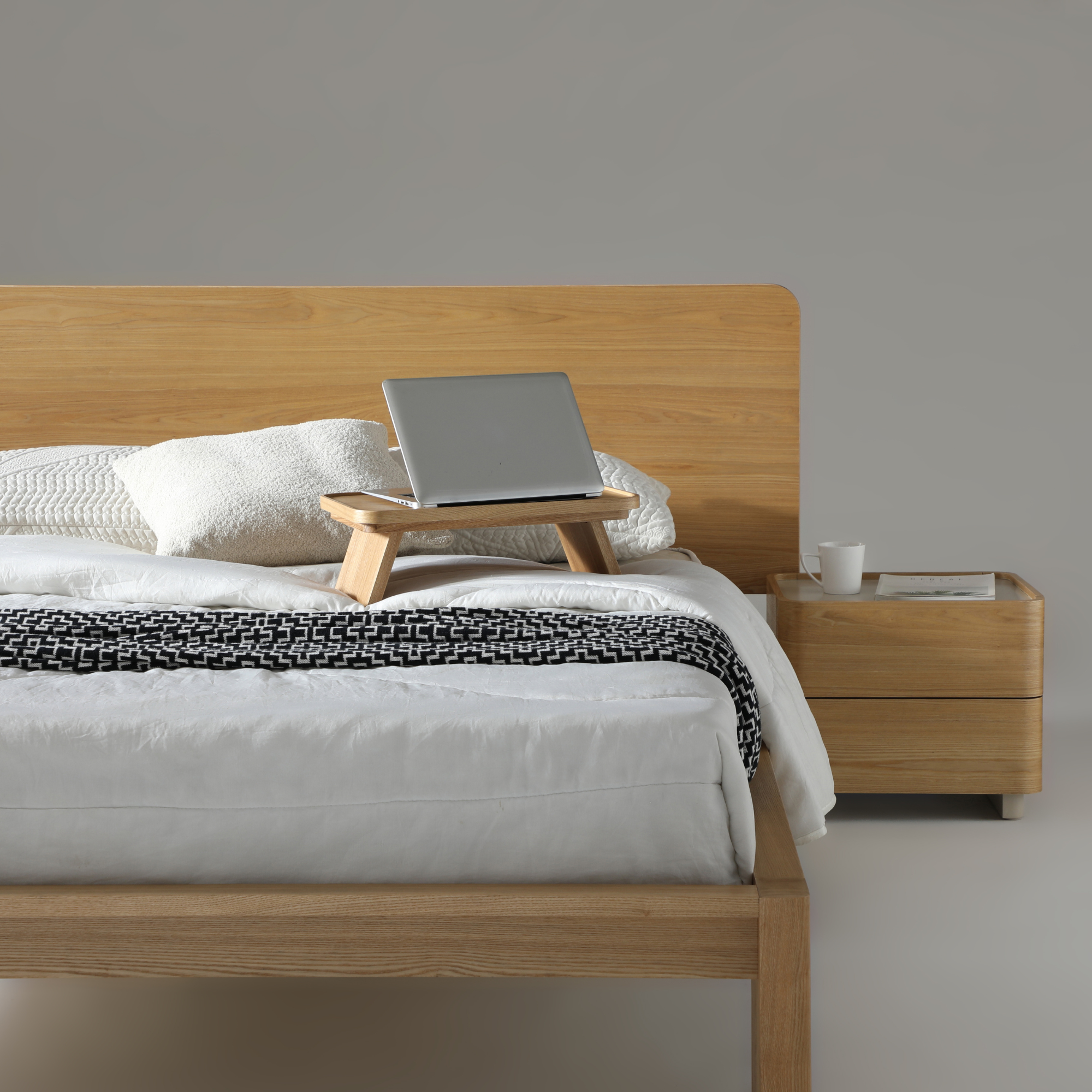 Stylish bedroom featuring Xara 2 Drawer Bedside in natural ash and warm grey with a laptop on a bed.