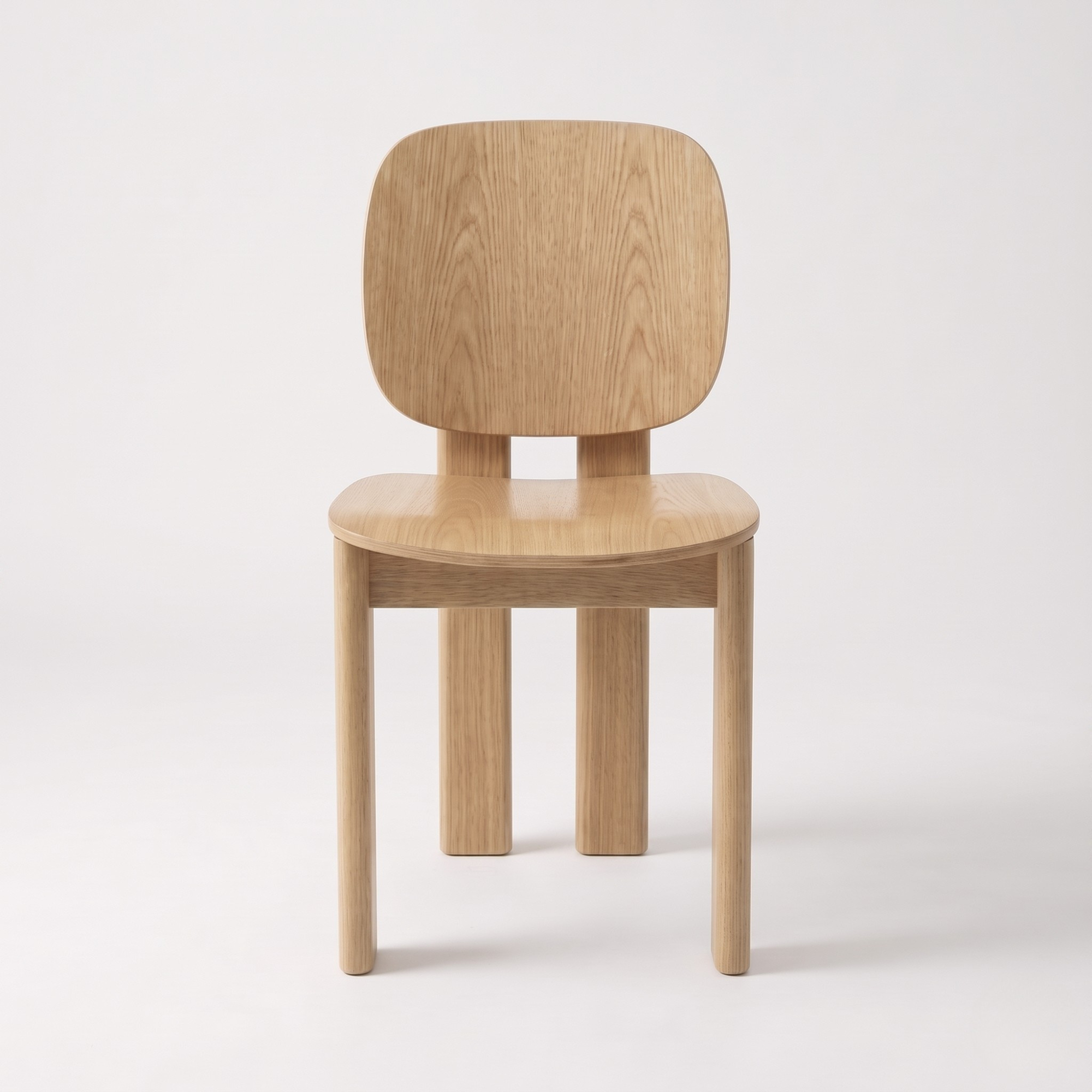 A minimalist light oak wood chair with a rounded rectangular backrest, a gently curved seat, and four straight legs, shown against a plain white studio background.