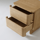 Close-up of Kiama 2 Drawer Bedside Table in natural ash, showcasing its spacious drawers and elegant wood grain finish.