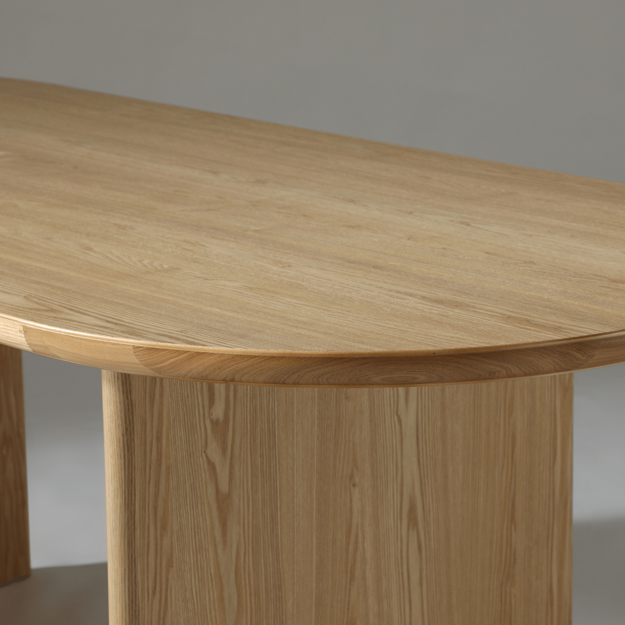 Close-up of the Kiama 2m Dining Table showcasing natural ash wood and soft curved edges.