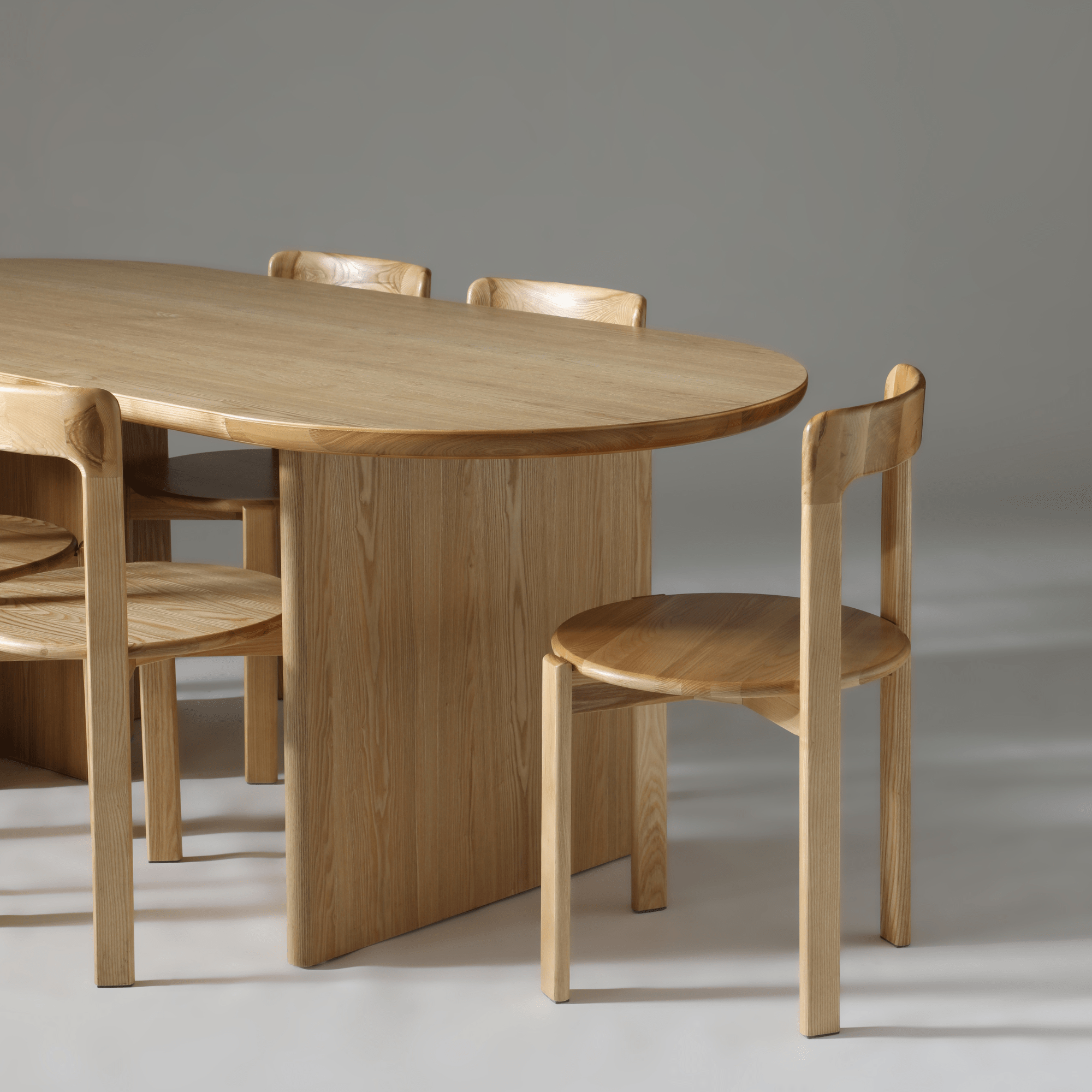 Kiama 2m Natural Ash Dining Table with curved edges and wooden chairs, ideal for modern dining decor.