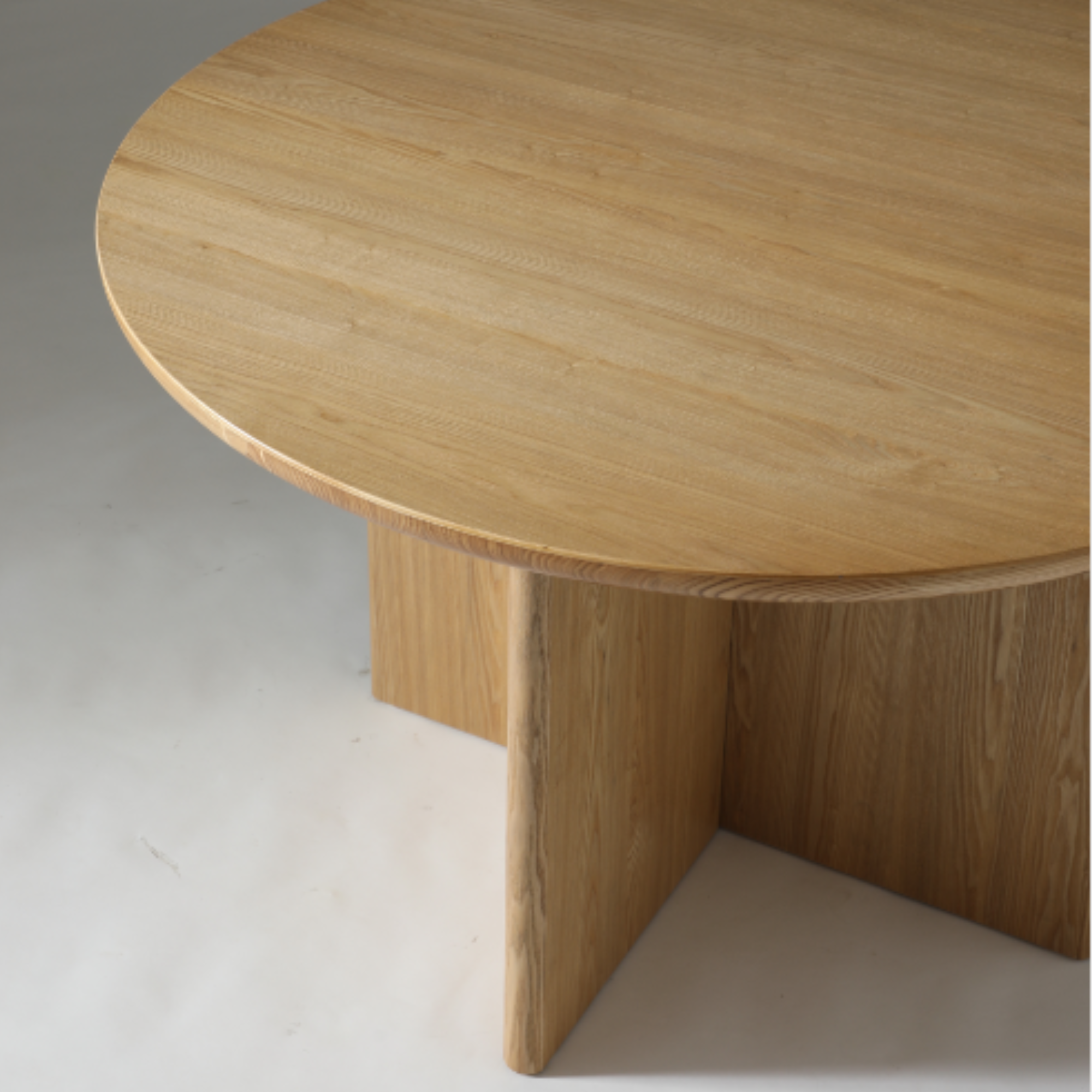 1.2m round timber dining table with Natural Ash veneer top and soft, organic edge detailing.