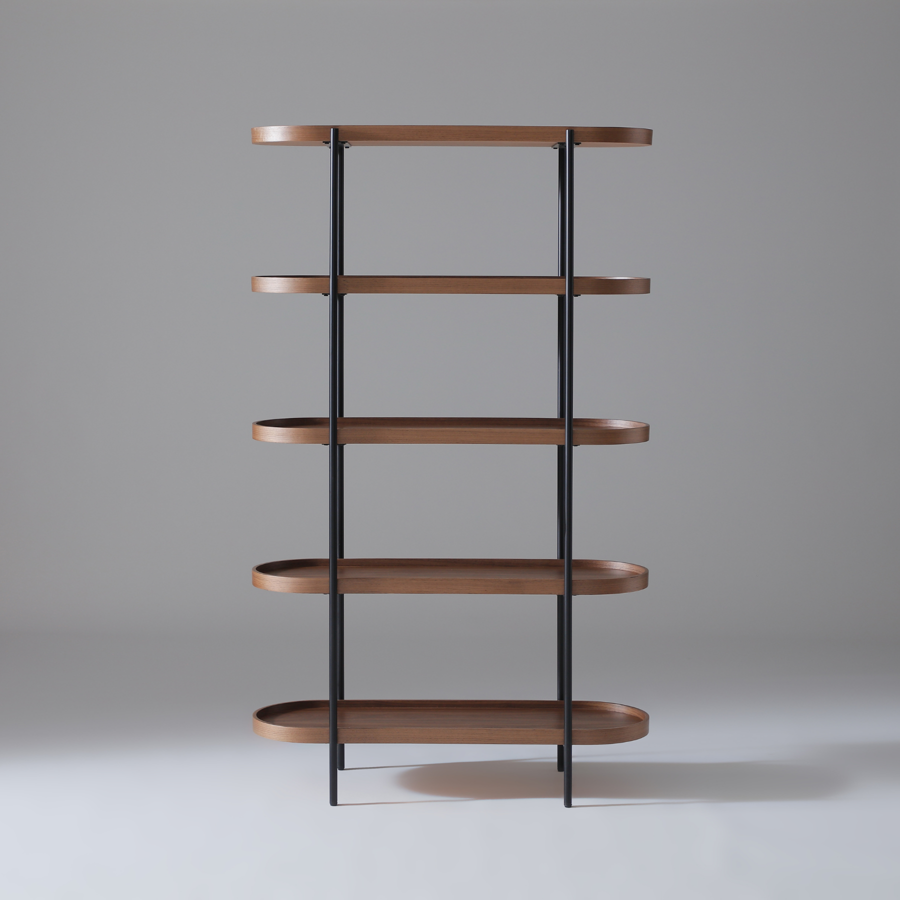 Cleo bookcase featuring five Walnut veneer shelves and a bold black powder-coated frame.