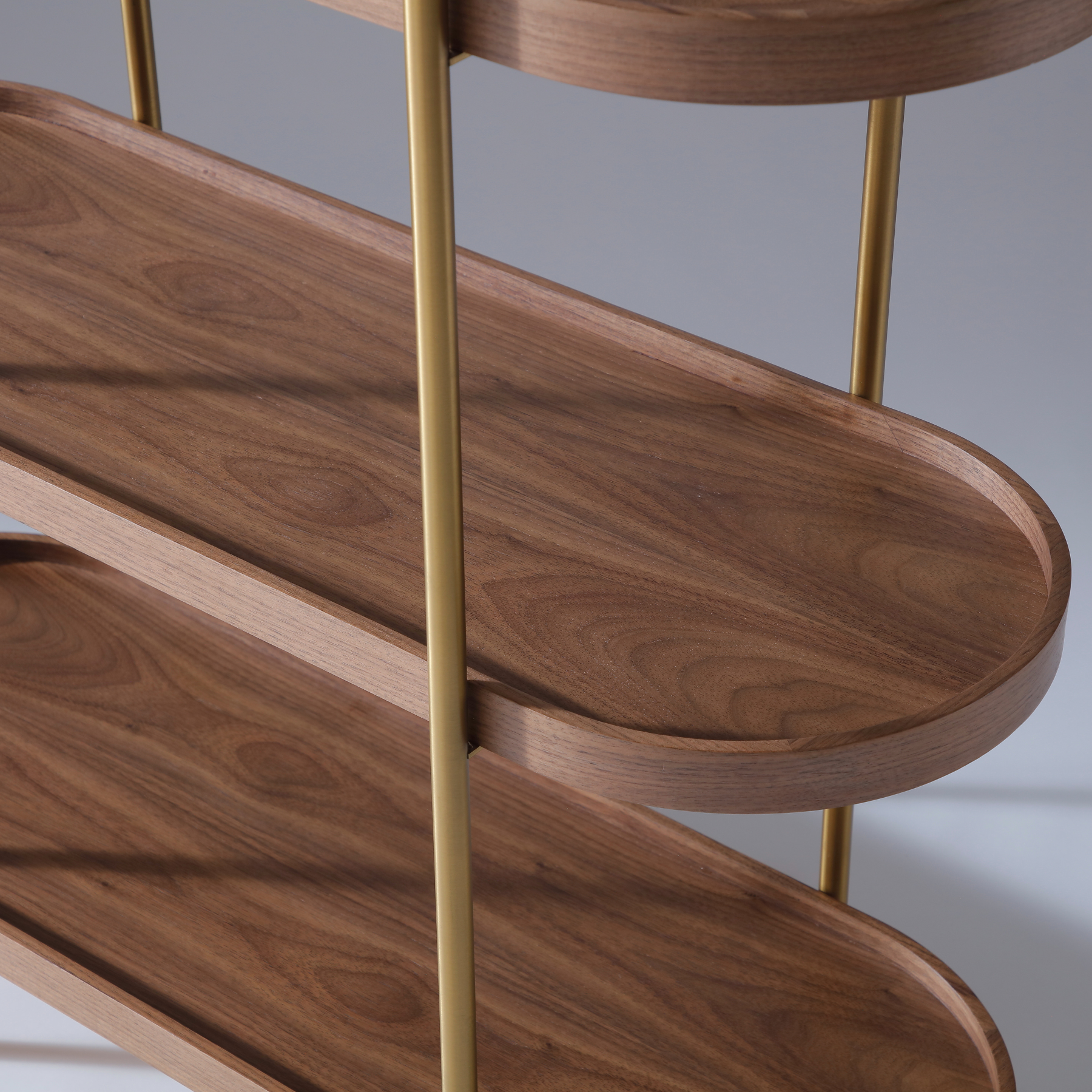Cleo shelving unit combining deep Walnut wood tones with a minimalist gold metal frame.