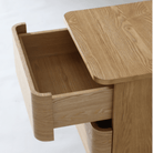Compact bedside cabinet with Natural Ash veneer body and dual Warm Grey storage drawers.