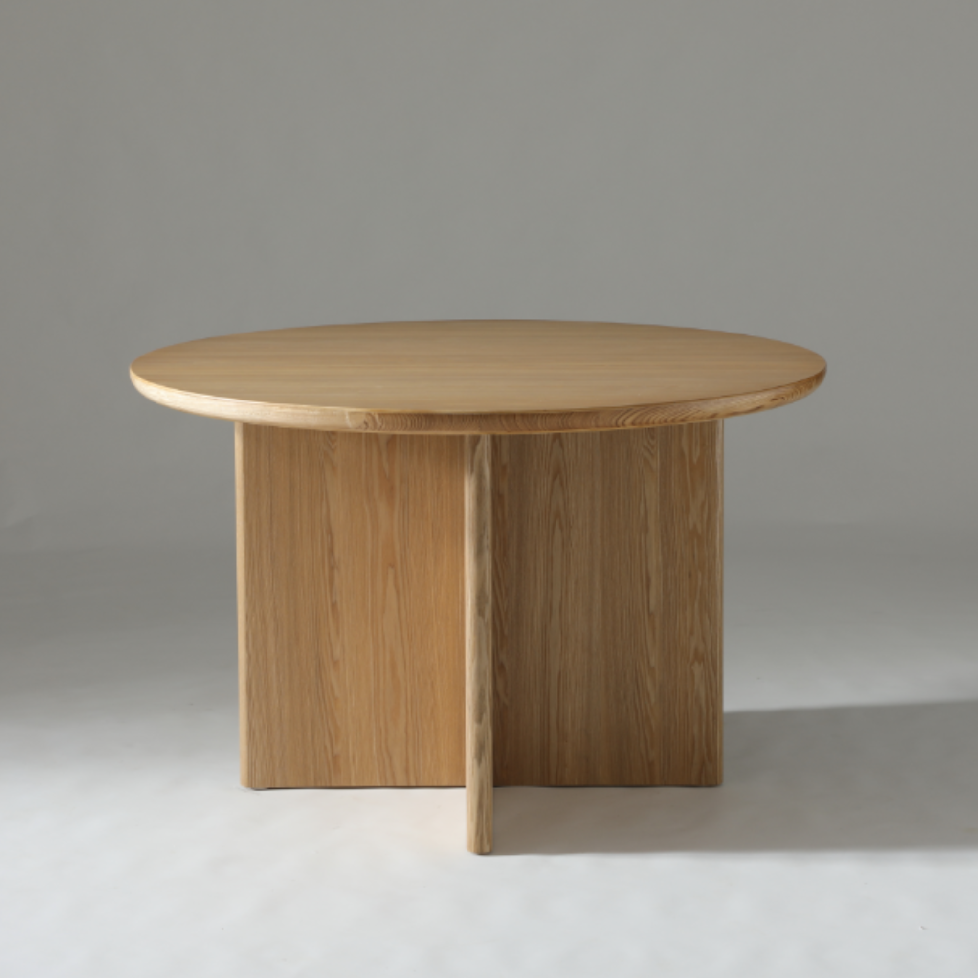 Kiama 1.2m Round Dining Table in Natural Ash with soft curved edges and contemporary design.

