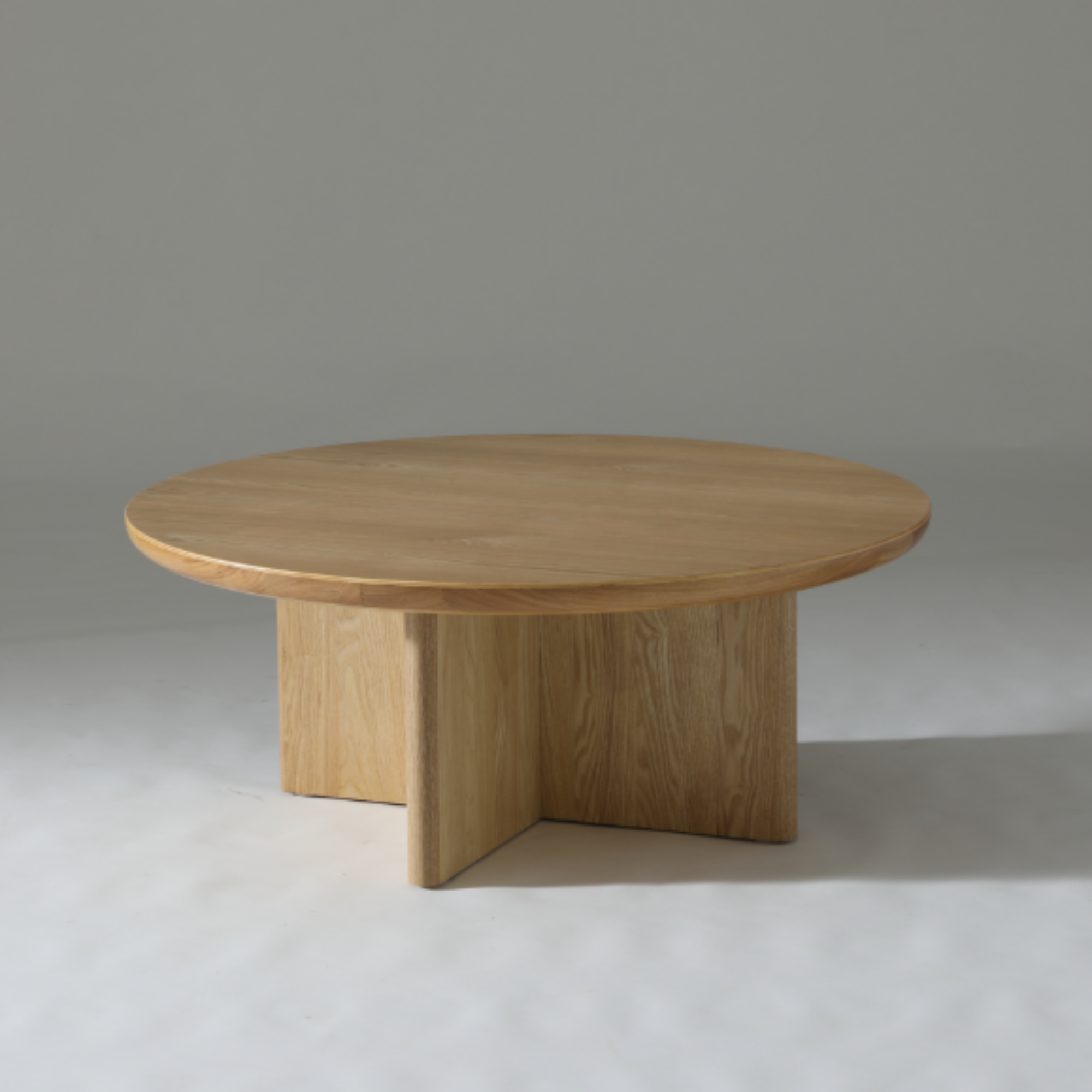 Kiama Round Coffee Table in Natural Ash with a modern, minimalist design and soft curved edges.