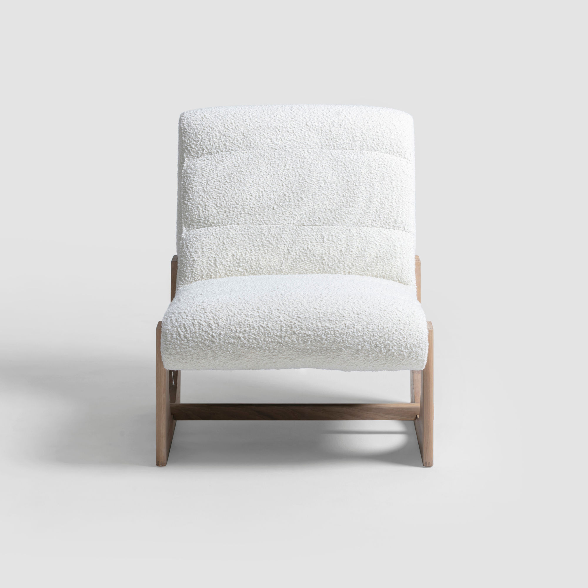 Modern lounge chair featuring natural boucle fabric and solid oak wood frame.