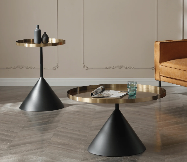 Modern black side table, 40 cm round ash top with black pedestal base, styled beside linen sofa, holding ceramic vase and stacked books.