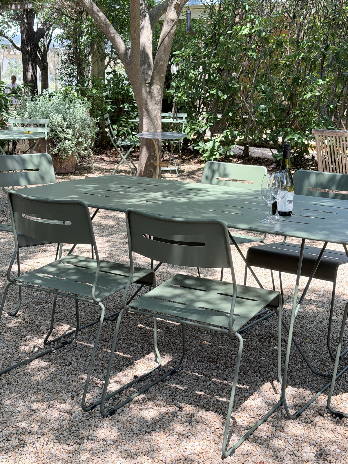 Parco Outdoor 7 Piece Dining Set in Olive triple powder-coated steel set up on gravel under trees at a Hunter Valley winery