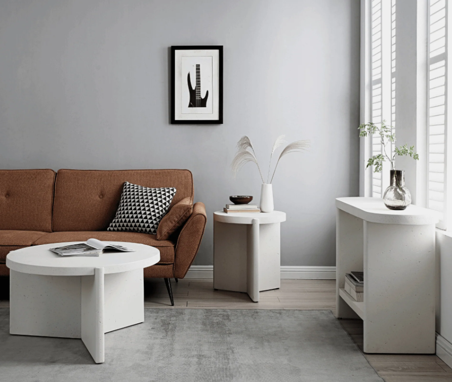 Delos white round coffee table, 80 cm faux-stone finish, soft curved edges, styled with neutral rug and linen sofa.